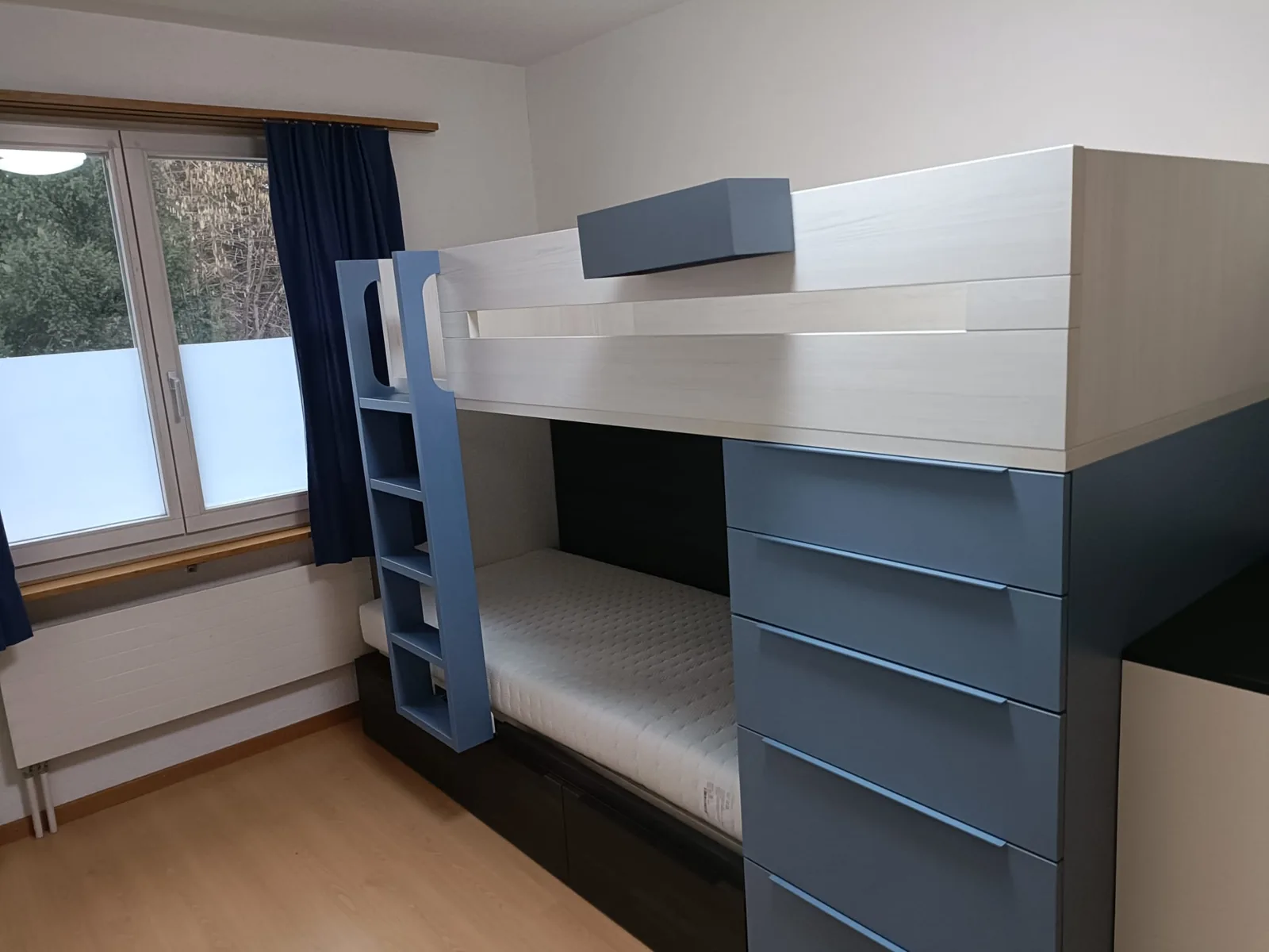 Blaues Hochbett mit Schubladenturm und Leiter